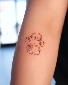 a person with a tattoo on their arm that has cats and dogs in the center