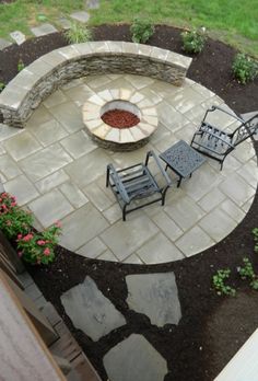 an outdoor fire pit with chairs around it