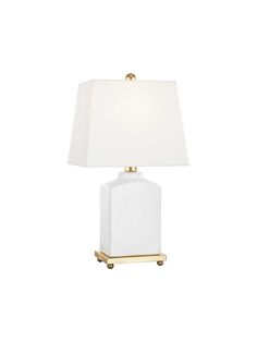 a white table lamp with a gold base