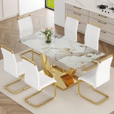 a marble dining table with gold legs and white chairs is shown in this modern kitchen