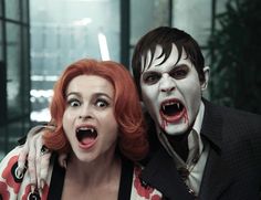 two people dressed in costumes posing for the camera with their mouths open and blood dripping all over them