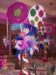 there are many balloons and streamers in the center of this party table setting,