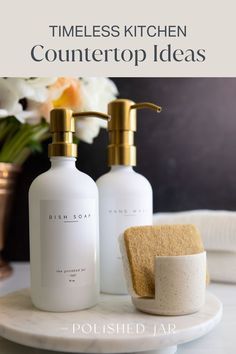 two soap dispensers sitting on top of a white counter next to a sponge