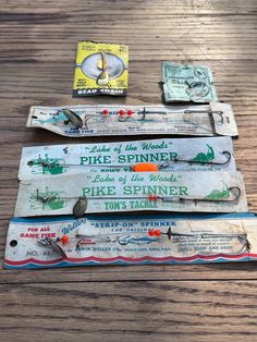 three old fishing lures are sitting on a wooden table next to two other items