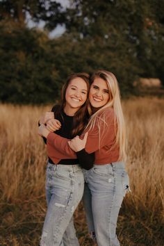 two women hugging each other in a field