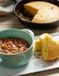 a blue bowl filled with beans next to a bundt cake on a white plate