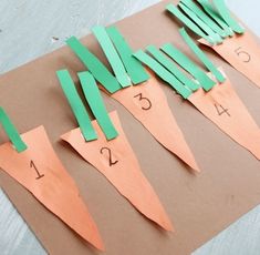 paper cut out to look like carrots on a piece of brown paper with numbers