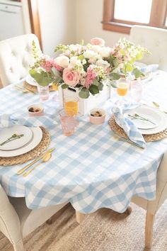 a table set for two with plates and flowers