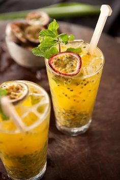 two glasses filled with drinks sitting on top of a table