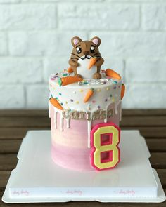 a birthday cake with a cat on top and the number eight in front of it