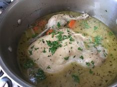 a pot filled with chicken, carrots and broth