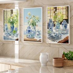 three paintings of blue and white vases on a wall above a kitchen countertop