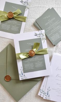 wedding stationery and envelopes with wax stamp on them are laid out on the table