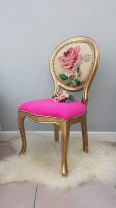 a pink and gold chair sitting on top of a white rug next to a wall