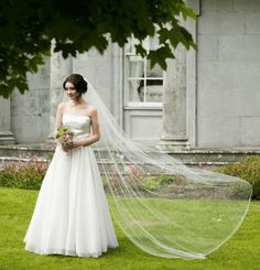 a woman in a wedding dress holding a veil