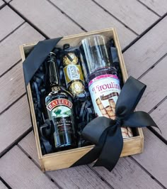 an open wooden box with liquor bottles and condiments in it on a deck