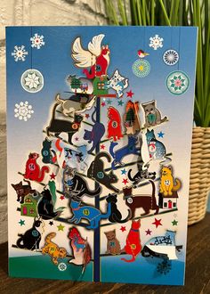 a christmas tree card with cats and dogs on it, surrounded by snowflakes