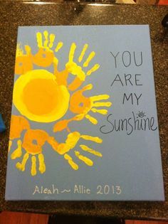 a handprinted canvas with the words you are my sunshine written on it and yellow hands