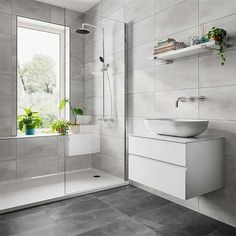 a bathroom with a sink, toilet and shower stall in the corner next to a window