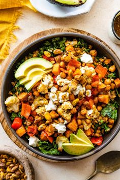 a bowl filled with chickpeas, carrots and avocado