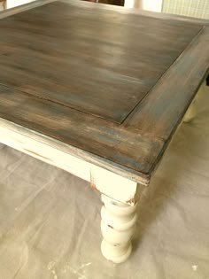 an old wooden table is being painted white