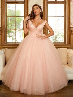 a woman in a pink ball gown posing for the camera