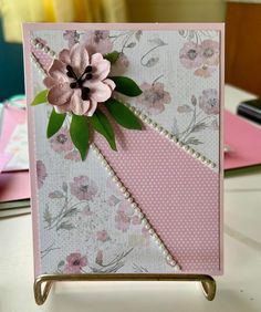 a close up of a card on a table with flowers and polka dotes in the background