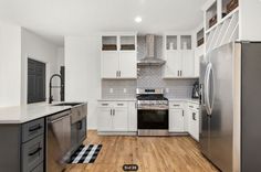 a kitchen with white cabinets and stainless steel appliances