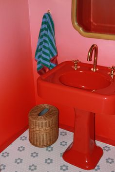 a red sink and mirror in a small bathroom