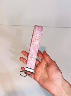 a hand holding a pink flowered lighter in it's palm