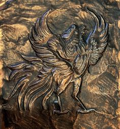 an intricately carved wooden plaque with a bird on it's back legs and wings