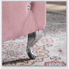 a close up of a pink chair on a rug with an ornate pattern and diamond accents