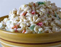 a yellow bowl filled with macaroni salad on top of a table