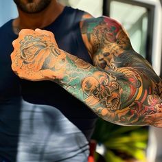 a man with many tattoos on his arms and arm is holding something in one hand