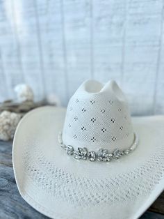 a white cowboy hat sitting on top of a wooden table