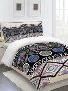 a bed room with a neatly made comforter and pillows on top of the bed