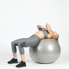 a woman is doing exercises on an exercise ball while holding her stomach in the air