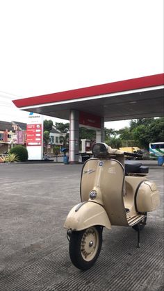 a scooter is parked in front of a gas station