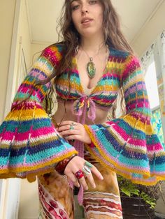 a woman in colorful clothing posing for the camera with her hand on her hippie