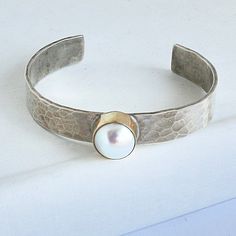 Please allow 3-5 weeks for this to be custom made and ship Sterling silver cuff with 14kt gold bezel and 1 Mother of Pearl Designed by Richard Schmidt Modern Hammered Cuff Jewelry, Richard Schmidt, Pearl Cuff, Hammered Sterling Silver, Pearl Design, Sterling Silver Cuff, Silver Cuff, Schmidt, 14kt Gold