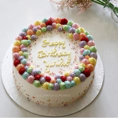 a birthday cake with the words happy birthday written in frosting surrounded by multicolored decorations