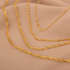 Our 14K Solid Gold Singapore Chain Necklace is a stunning example of artisan craftsmanship and stylish design. This exquisite necklace showcases a unique twisted rope pattern known as the Singapore chain, which offers both visual appeal and a comfortable wearing experience. Crafted from real 14K solid gold, this piece is designed to be both durable and luxurious. The hollow link construction provides a lightweight feel, perfect for daily wear or special occasions. Available in thicknesses rangin Luxury Gold Elegant Rope Chain Necklace, Luxury Gold Figaro Chain Rope Necklace, Elegant Twisted Chain Necklace Gift, Elegant Twisted Chain Necklace For Gift, Rope Pattern, Gold Heart Ring, Rope Design, Love Ring, Exquisite Jewelry