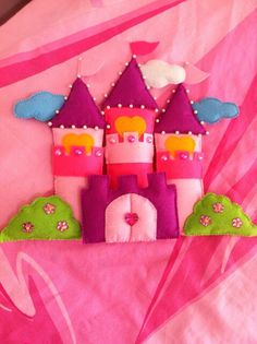 a close up of a pink bed with a castle on it