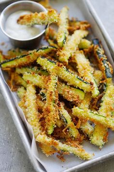 fried zucchini fries on a white tray with dipping sauce