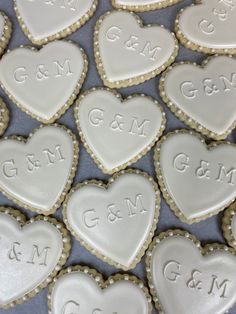 heart shaped cookies with the names and date on them are arranged in a pattern to be used as wedding favors