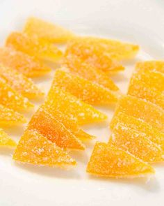 orange slices are arranged in rows on a white plate, ready to be cut into wedges