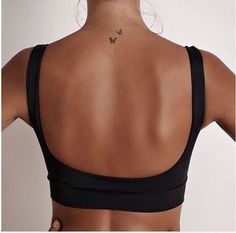 the back of a woman's bra with a butterfly tattoo on her left shoulder