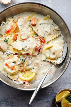 a bowl filled with mashed potatoes covered in gravy and garnished with lemon wedges