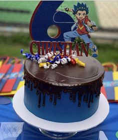 a birthday cake with chocolate frosting and decorations on the top is decorated with an image of cartoon characters