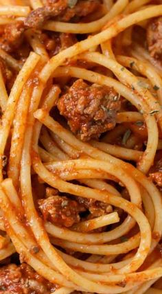 spaghetti with meat sauce and parmesan cheese on top, close up view from above